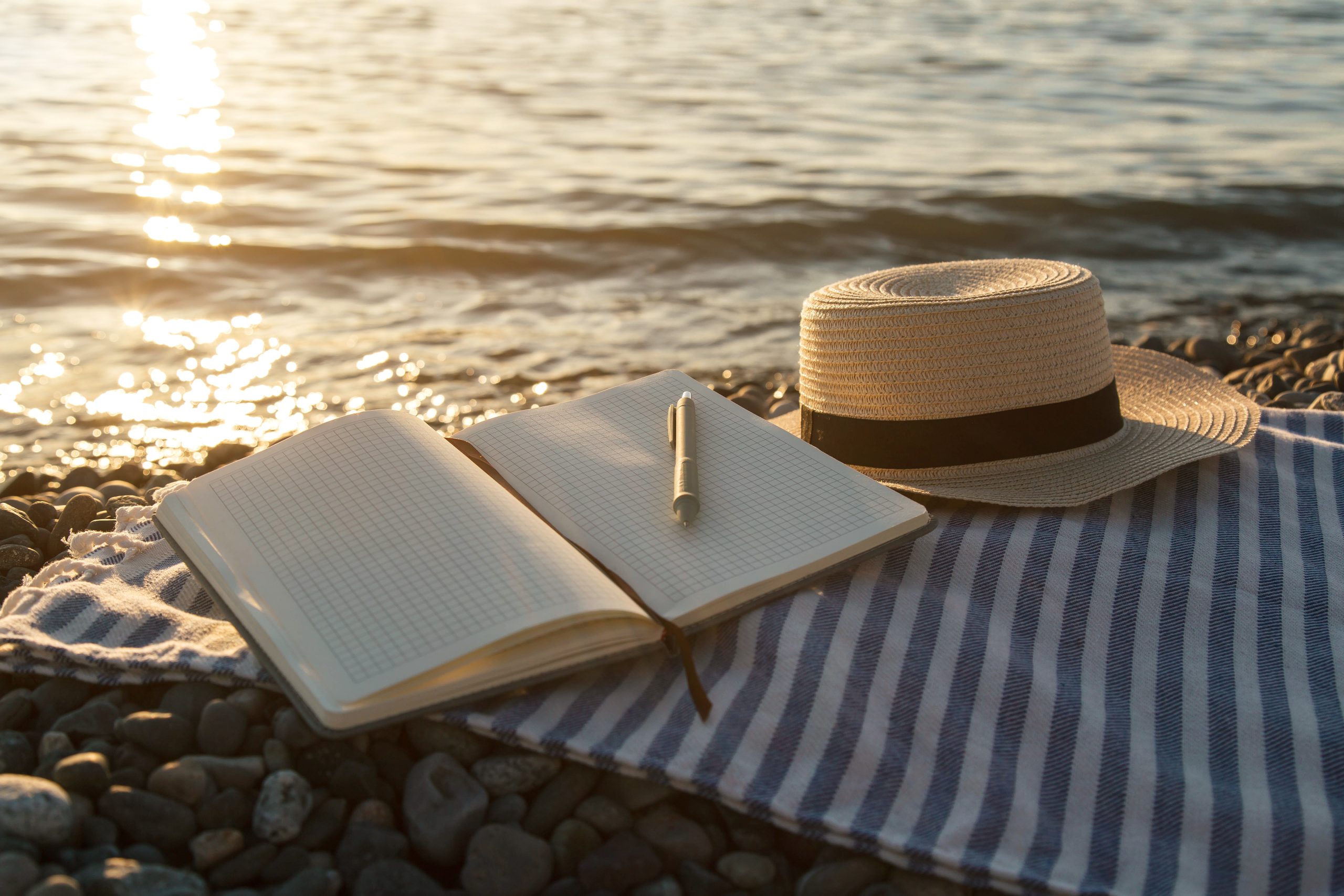 Open journal by the water representing reflection, writing prompts, and renewal.
